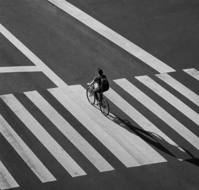 骑车人穿过有光影变化的街道路口