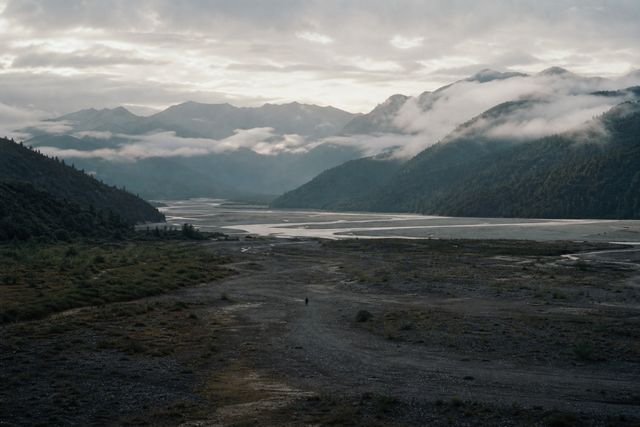 云雾越过群山，河流在开阔的山谷中延伸